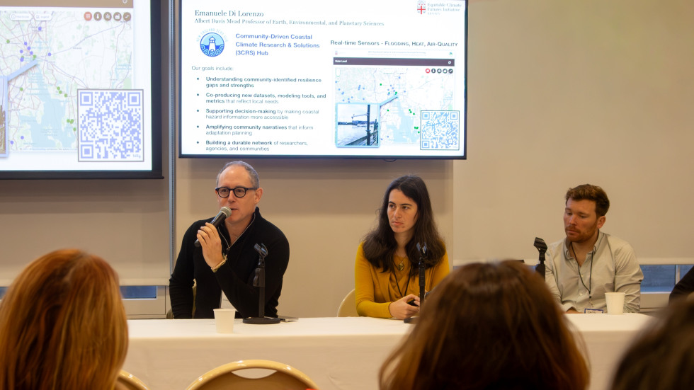 Panelists sitting at a table and presenting research